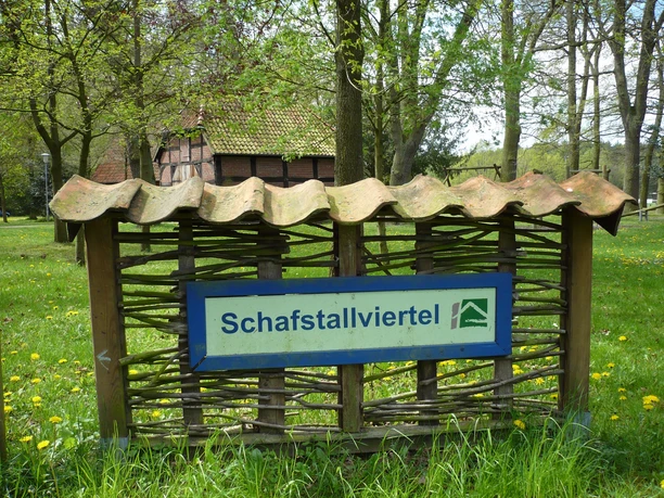 Hinweis auf das Schafstallviertel Hülsen, umgeben von grüner Wiese und ländlicher Kulisse.