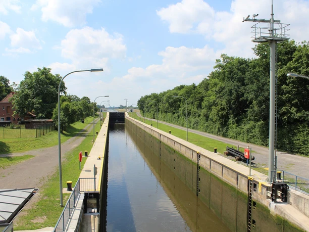 Schleuse Schlüsselburg Schleuse Schlüsselburg an einem sonnigen Tag, umgeben von Wasser und Bäumen auf einem ruhigen Pfad.