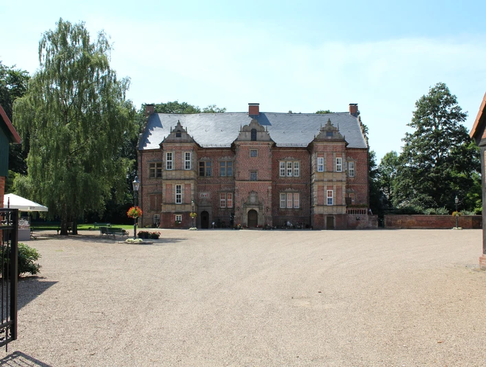 Historisches Schloss Erbhof Thedinghausen mit Backsteinfassade und großzügigem Vorplatz im Sommer.Historic castle Erbhof Thedinghausen with brick façade and spacious forecourt in summer.Det historiske slot Erbhof Thedinghausen med murstensfacade og stor forplads om sommeren.Historisch kasteel Erbhof Thedinghausen met bakstenen gevel en ruim voorplein in de zomer.