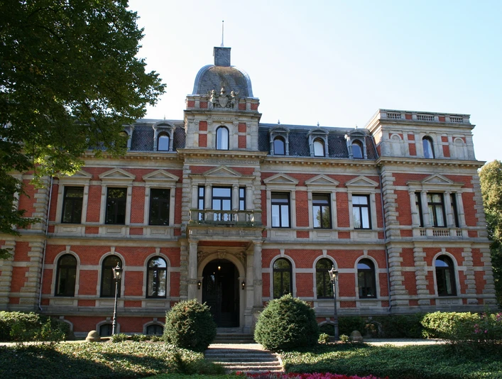 Ziegelsteinfassade mit Türmchen und Erkern, umgeben von gepflegter Gartenanlage vor Schloss Etelsen.Brick façade with turrets and bay windows, surrounded by well-tended gardens in front of Etelsen Castle.Murstensfacade med tårne og karnapper, omgivet af velplejede haver foran Etelsen Slot.Bakstenen gevel met torentjes en erkers, omgeven door goed onderhouden tuinen voor het kasteel van Etelsen.