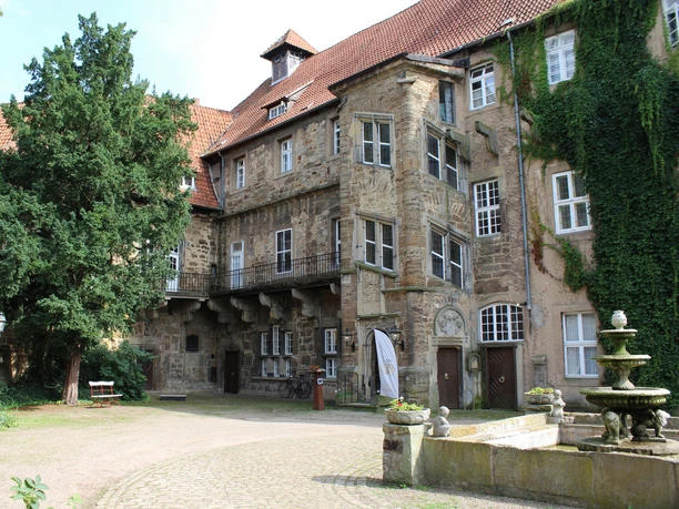 Historisches Schloss Petershagen mit prächtiger Fassade aus Naturstein und rotem Ziegeldach.