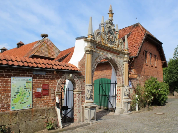 Weserrenaissance-Tor seitlich Seitlich aufgenommene Perspektive eines kunstvollen Weserrenaissance-Tors mit rotem Backsteingebäude.