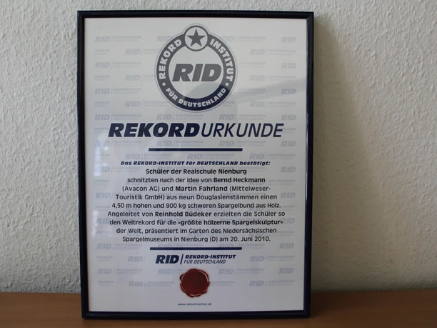 Urkunde Spargelskulptur Urkunde zur Anerkennung des größten Spargelsupermarkts, verliehen an die Realschule Nienburg 2010.