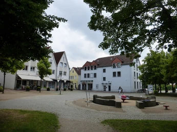 Alter Markt Historischer Platz mit Gebäuden im traditionellen Stil, umgeben von Bäumen, zeigt eine ruhige Szene.