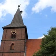 St. Aegidien-Kirche Rodewald Backsteinkirche mit markantem Kirchturm und Uhr in grüner Umgebung unter blauem Himmel.