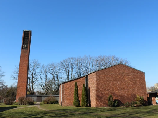 St. Michaelskirche Nienburg mit markantem rechteckigen Glockenturm aus rotem Backstein und weitläufigem Kirchengelände.