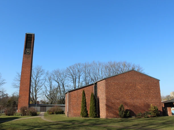 St. Michaelskirche Nienburg mit markantem rechteckigen Glockenturm aus rotem Backstein und weitläufigem Kirchengelände.