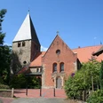 St.-Clemens-Romanus-Kirche in Marklohe, rot verklinkert mit markantem Kirchturm und grüner Umgebung.