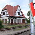 Südbahnhof Weyhe Ein historisches Fachwerkgebäude steht neben Gleisen unter einem wolkigen Himmel am Südbahnhof Weyhe.
