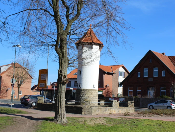 Stadt Rehburg-Loccum Uhrturm Der historische Uhrturm von Rehburg-Loccum mit rotem Ziegeldach, umgeben von Bäumen und Wohnhäusern.