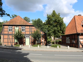 Wassermühle Sudweyhe Historische Fachwerkgebäude der Wassermühle Sudweyhe an einer ruhigen Straße, umgeben von Bäumen.