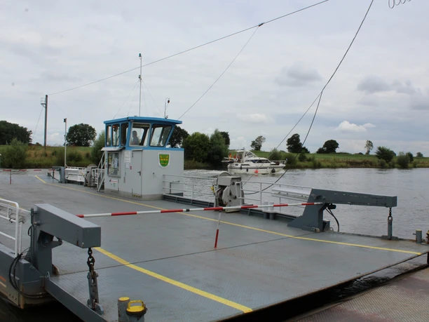 Weserfähre Schweringen Autofähre auf der Weser bei Schweringen, mit Autos an Bord und Bäumen am Flussufer im Hintergrund.