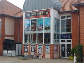 Weyher Theater mit roter Backsteinfassade, Plakaten aktueller Stücke und Eingangsbereich.