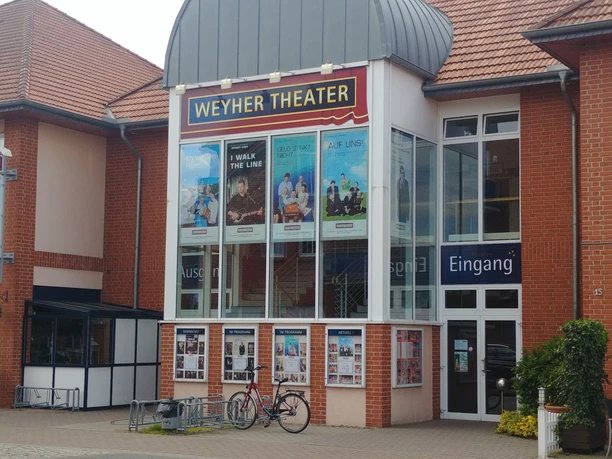 Weyher Theater Weyher Theater mit roter Backsteinfassade, Plakaten aktueller Stücke und Eingangsbereich.