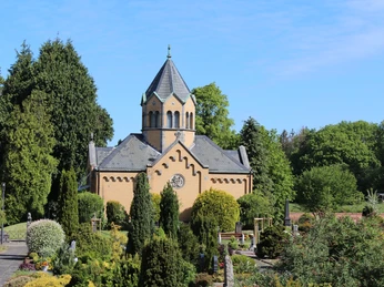 Mausoleum Eystrup Backstein-Mausoleum mit sechseckigem Turm, umgeben von gepflegten Gärten und grünen Bäumen.