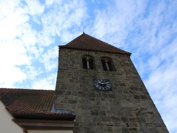 Willehadikirche Eystrup Romanische Kirche in Eystrup mit markantem, eckigen Steinturm und einer großen Uhr.