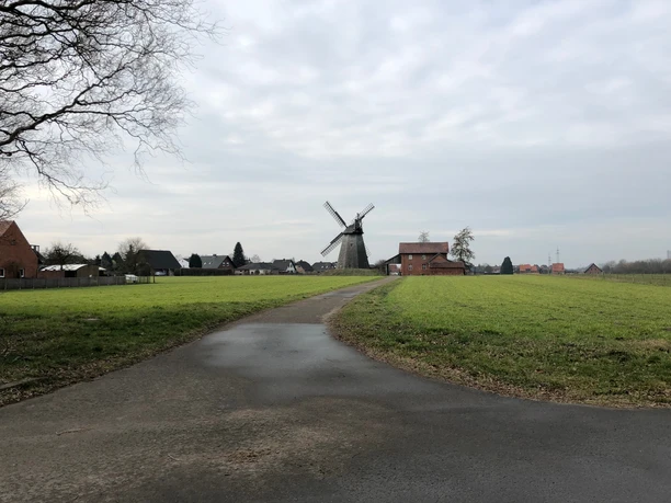 Windmühle Bierde Windmühle Bierde in norddeutscher Landschaft, umgeben von grünen Feldern und einem bewölkten Himmel.