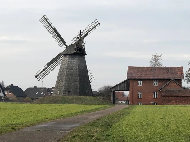 Windmühle Bierde Historische Windmühle Bierde aus Backstein mit rustikaler Scheune, umgeben von grünen Wiesen.