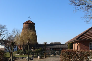 Mühle Nienburg-Erichshagen Historische Windmühle mit Backsteingebäuden im strahlenden Sonnenschein eines klaren Tages.