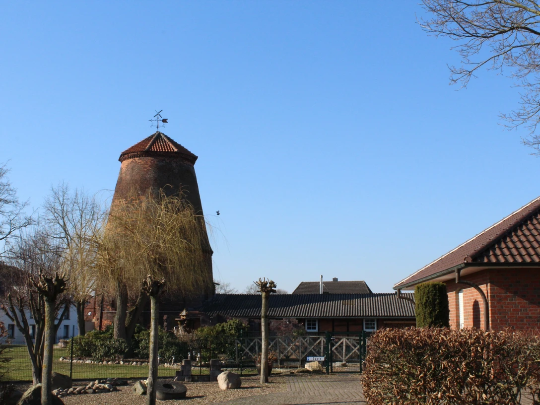 Mühle Nienburg-Erichshagen Historische Windmühle mit Backsteingebäuden im strahlenden Sonnenschein eines klaren Tages.