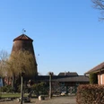 Mühle Nienburg-Erichshagen Historische Windmühle mit Backsteingebäuden im strahlenden Sonnenschein eines klaren Tages.
