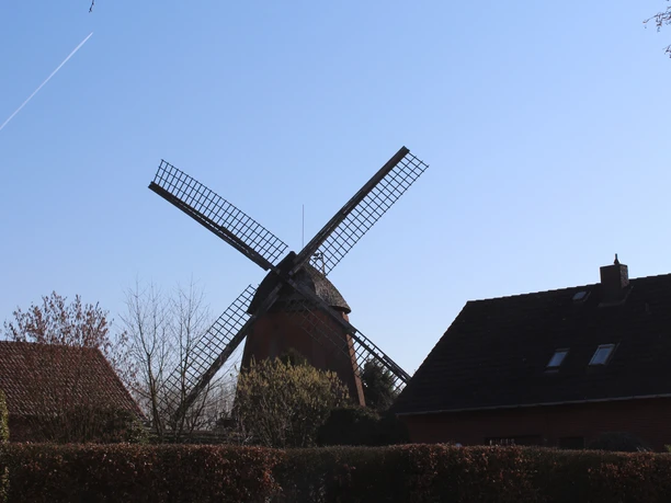 Windmühle im Nienburger Leintor Windmühle mit markanten Flügeln und Backsteinbauten im Vordergrund unter blauem Himmel in Nienburg.