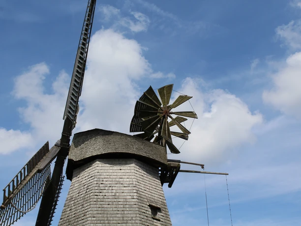 Windmühle Meßlingen Historische Windmühle mit hölzernem Schindeldach und großen Flügeln vor blauem Himmel mit Wolken.