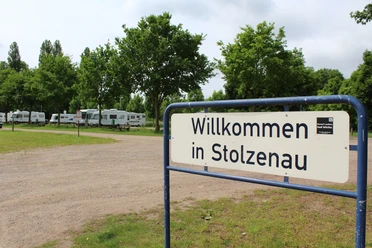 Wohnmobilstellplatz Stolzenau Willkommen in Stolzenau: Wohnmobilstellplatz, umgeben von grünen Bäumen und zahlreichen Wohnmobilen.