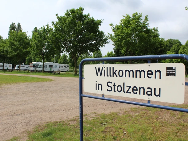 Wohnmobilstellplatz Stolzenau Willkommen in Stolzenau: Wohnmobilstellplatz, umgeben von grünen Bäumen und zahlreichen Wohnmobilen.