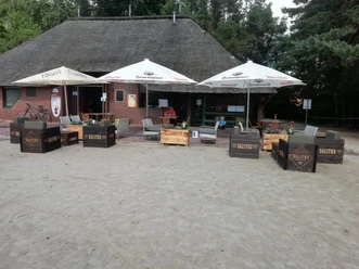kiosk-1 Haus davor stehen Sitzgruppen und Sonnenschirme