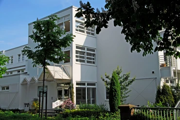 Artemed Fachklinik Prof. Dr. Dr. Salfeld Auf dem Bild ist die weiße Fassade der Klinik zu sehen, die ein modernes Gebäude darstellt. Umgeben wird es von Bäumen, die eine natürliche Atmosphäre schaffen.