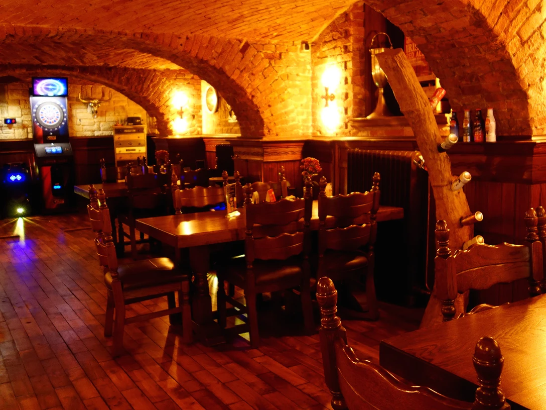 Barnies_Pub_Katrin Jester (3)_1980x1080.jpg Gewölbekeller mit Holzboden und warmer, gemütlicher Beleuchtung