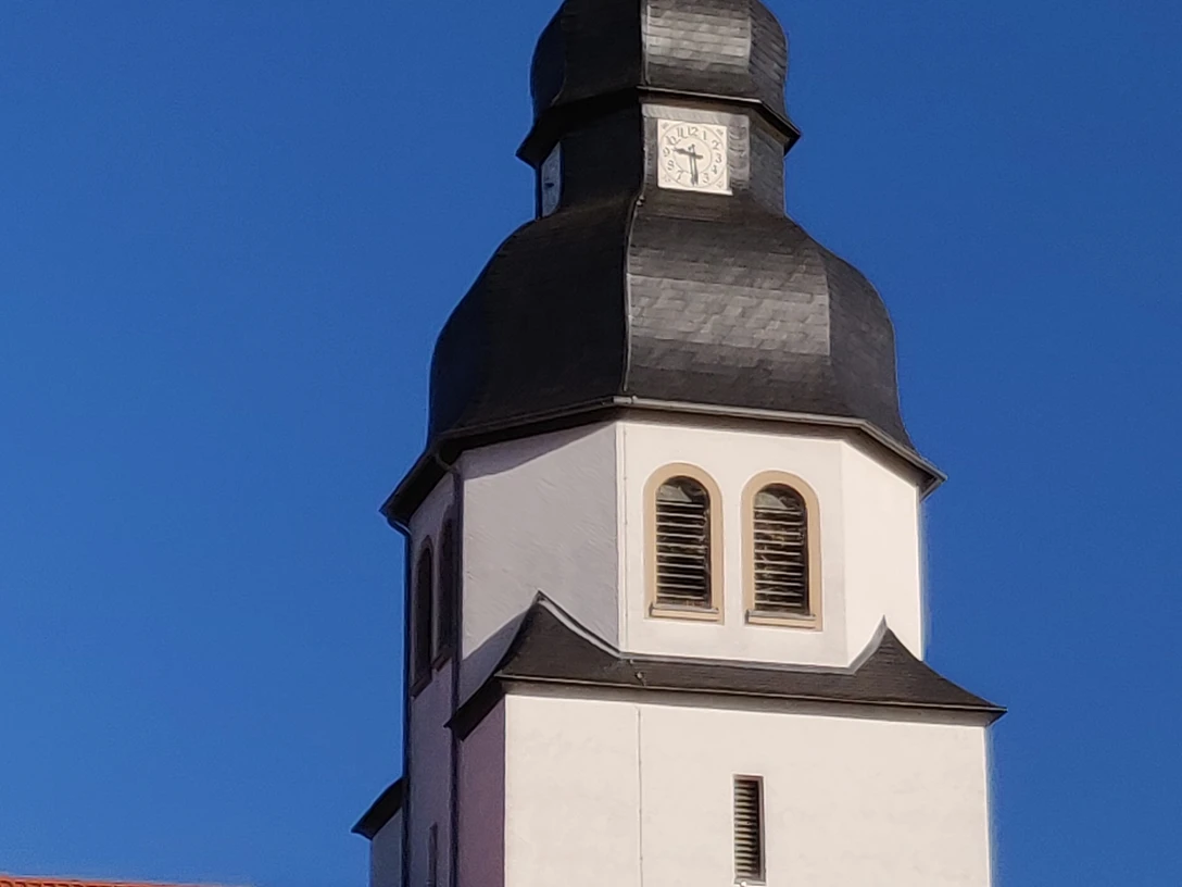 Kirchturm St Johannes_HRenerig .jpg Kirchturm der St. Johannes-Kirche mit markanter Zwiebelhaube vor klarem blauen Himmel.