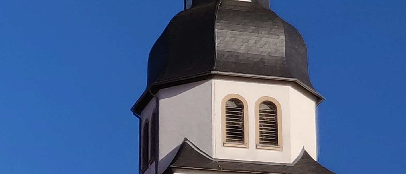 Kirchturm St Johannes_HRenerig .jpg Kirchturm der St. Johannes-Kirche mit markanter Zwiebelhaube vor klarem blauen Himmel.