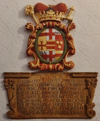 Wappen an der Kirche St. Johannes Baptist_HRenerig.jpg Wappenrelief mit historischer Inschrift, verziert mit Kronen und Wappenmotiven, an der Kirchenwand.
