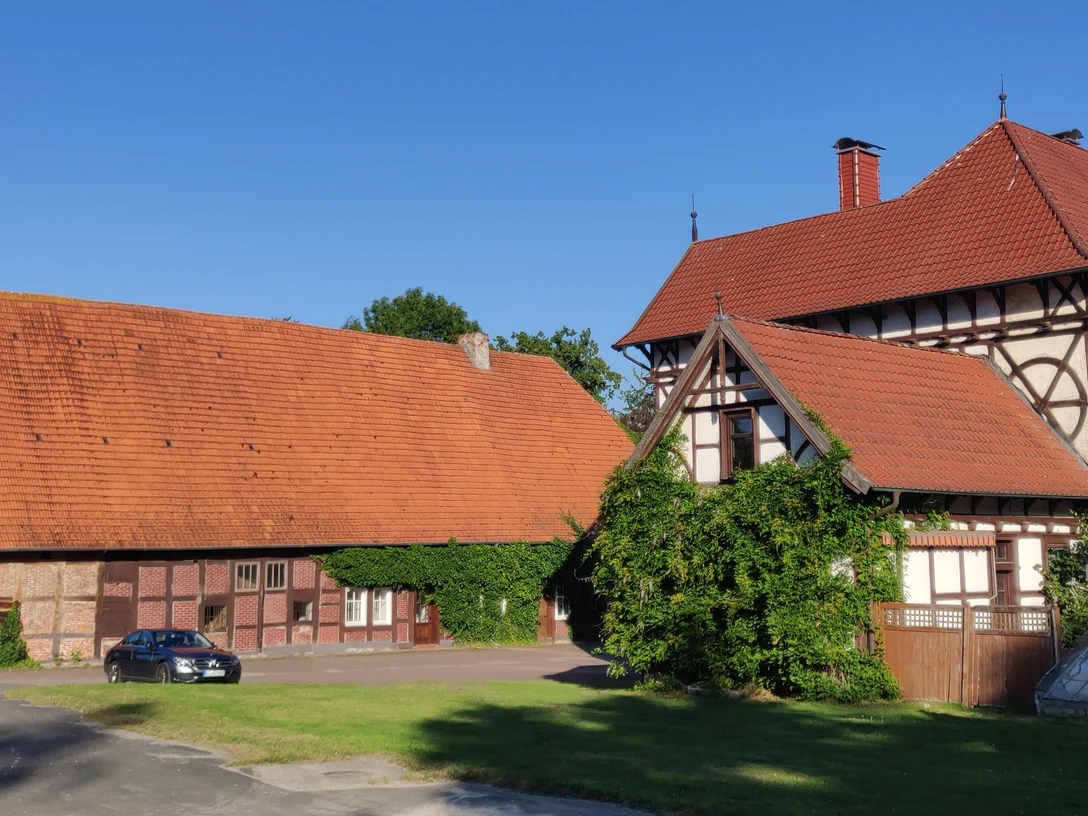 HRenerig Gutshof + alte Vogtei.jpg Gutshof mit Fachwerkhaus und Scheune unter blauen Himmel, rote Dächer und grüne Vegetation.