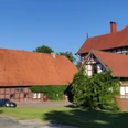 HRenerig Gutshof + alte Vogtei.jpg Gutshof mit Fachwerkhaus und Scheune unter blauen Himmel, rote Dächer und grüne Vegetation.