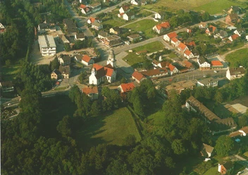 HRenerig Stukenbrock ca 1970.jpg Luftaufnahme einer historischen Ortschaft mit Kirche, viel Grünflächen und einigen weißen Gebäuden.