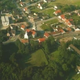 HRenerig Stukenbrock ca 1970.jpg Luftaufnahme einer historischen Ortschaft mit Kirche, viel Grünflächen und einigen weißen Gebäuden.