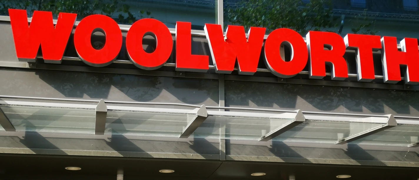 Woolworth.jpg Das Bild zeigt das Schild "Woolworth" über dem Eingang des Geschäftes.