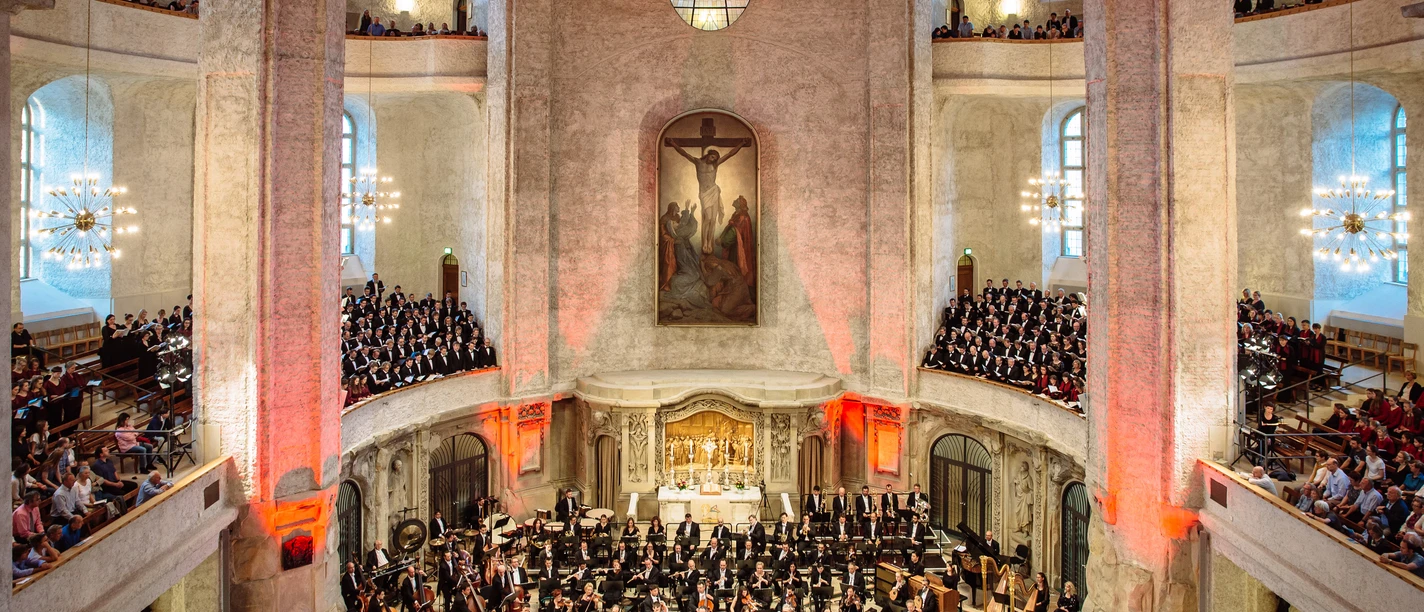 Dresdner Musikfestspiele_Kreuzkirche Dresden_Oliver Killig.jpg Ein voll besetztes Orchester spielt in einer großzügigen, kunstvoll beleuchteten Kirchenhalle.