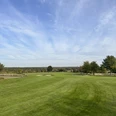 Golf Park Steinhuder Meer Weitläufige Golfwiese mit tiefblauem Himmel, umgeben von vereinzelten Bäumen am Horizont.Extensive golf meadow with a deep blue sky, surrounded by scattered trees on the horizon.En stor golfeng med en dybblå himmel, omgivet af spredte træer i horisonten.Uitgestrekte golfweide met een diepblauwe lucht, omringd door verspreide bomen aan de horizon.