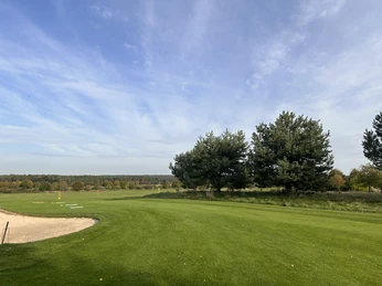 Golf Park Steinhuder Meer Weitläufiger Golfplatz mit grünem Rasen, angrenzendem Sandbunker und hohen Bäumen im Hintergrund.Extensive golf course with green lawn, adjacent sand bunker and tall trees in the background.Omfattende golfbane med grøn græsplæne, nærliggende sandbunker og høje træer i baggrunden.Uitgestrekte golfbaan met groen gazon, naburige zandbunker en hoge bomen op de achtergrond.
