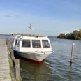 Fahrgastschiff an einem Steg im Wasser, ruhige Umgebung, leichter Wellengang unter blauem Himmel.Passenger ship on a jetty in the water, calm surroundings, light swell under a blue sky.Passagerskib på en mole i vandet, rolige omgivelser, lette dønninger under en blå himmel.Passagiersschip aan een steiger in het water, kalme omgeving, lichte deining onder een blauwe lucht.