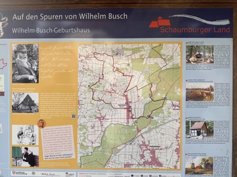 Informationstafel über das Wilhelm-Busch-Geburtshaus in Wiedensahl mit Wanderkarte und Fotos.