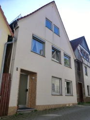 Ferienhaus Das Nelkenhaus.JPG Ferienhaus mit hellem Putz, drei Etagen und großen Fenstern, steht in einer ruhigen Straße.