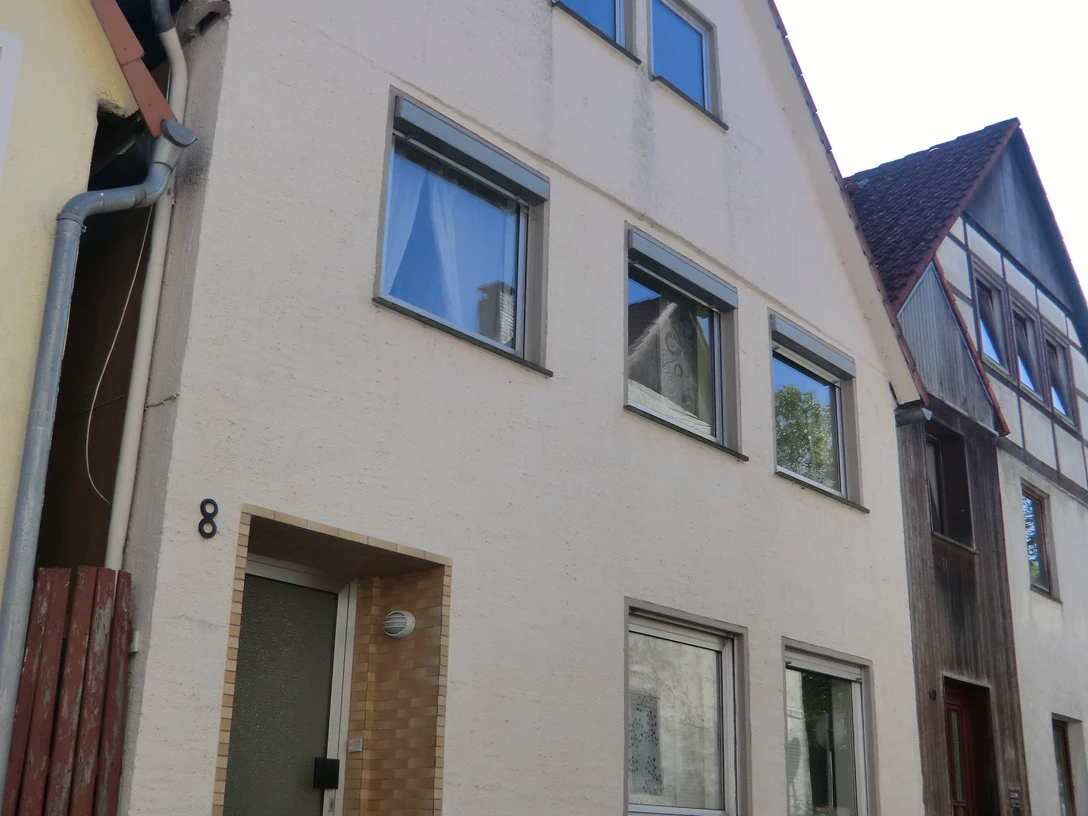 Ferienhaus Das Nelkenhaus.JPG Ferienhaus mit hellem Putz, drei Etagen und großen Fenstern, steht in einer ruhigen Straße.