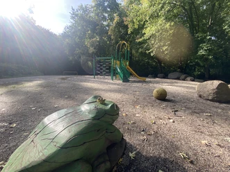 Spielplatz Marienweg - Familienurlaub in Leipzig Schattiger Spielplatz, der an ein Schloss erinnert mit hölzernem Froschkönig.