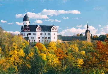 1969_Schloss Rochsburg_(c)_Manfred Lohse.jpg Schloss Rochsburg thront majestätisch über farbenfrohem Herbstwald, blauer Himmel im Hintergrund.