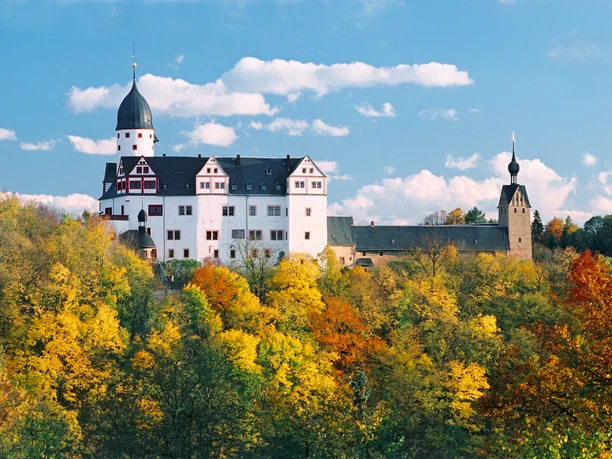 1969_Schloss Rochsburg_(c)_Manfred Lohse.jpg Schloss Rochsburg thront majestätisch über farbenfrohem Herbstwald, blauer Himmel im Hintergrund.